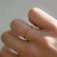 Detalle del Anillo Nara en el dedo: varias amatistas pequeñas sobre banda fina
