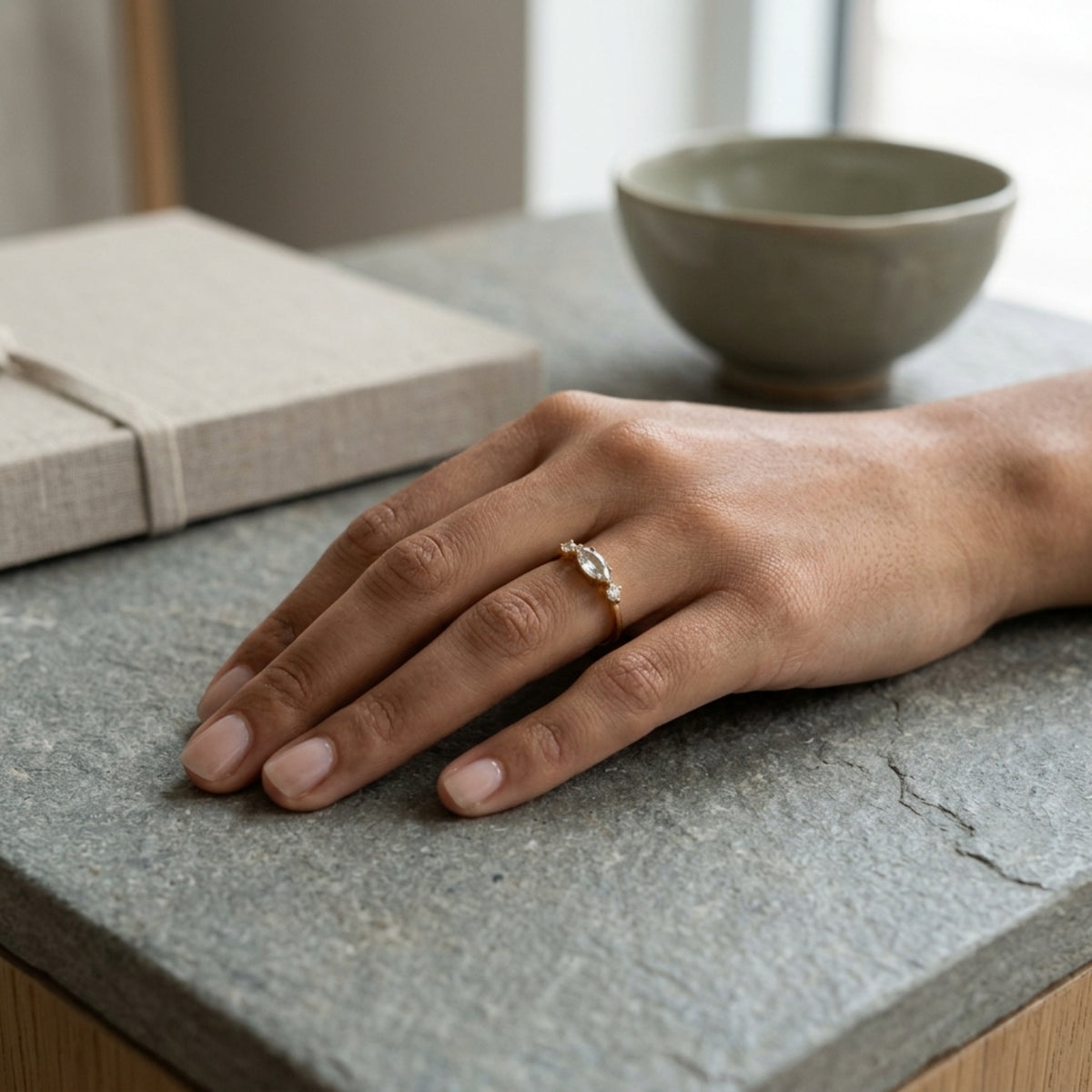 Mano apoyada en una mesa de piedra con el Anillo Nova puesto