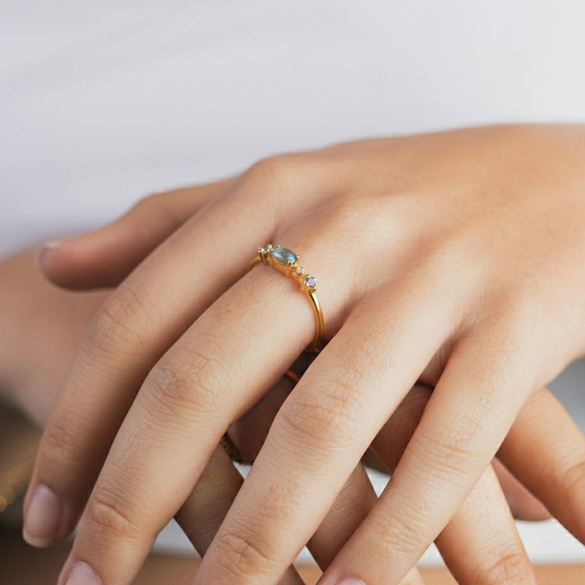 Manos juntas con el Anillo Nova de labradorita en el dedo