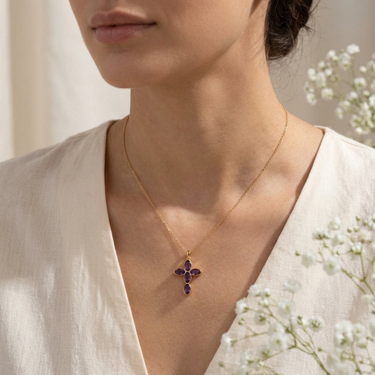 Collar Amara con cruz de amatista puesto sobre una blusa blanca