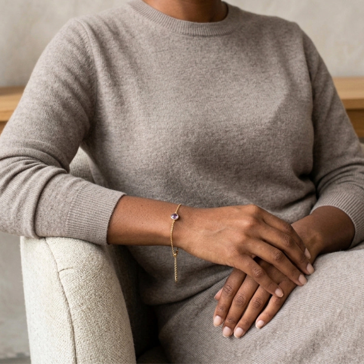 Mujer con jersey gris luciendo la Pulsera Elora de amatista