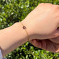 Pulsera Elora de amatista en la muñeca, al aire libre entre vegetación