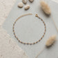 Pulsera Gaia de labradorita natural sobre plata de ley 925 dorada, en fondo gris
