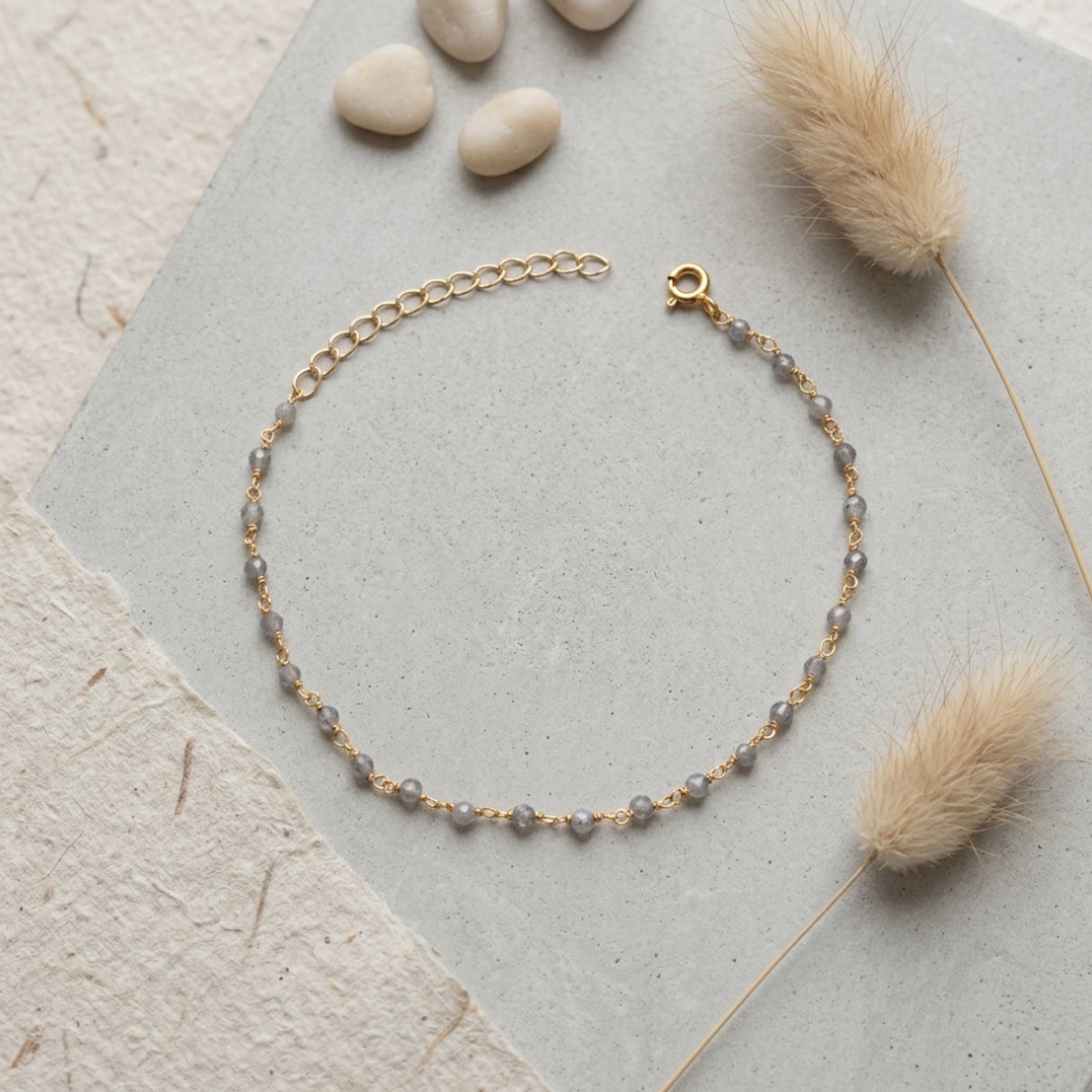 Pulsera Gaia de labradorita natural sobre plata de ley 925 dorada, en fondo gris