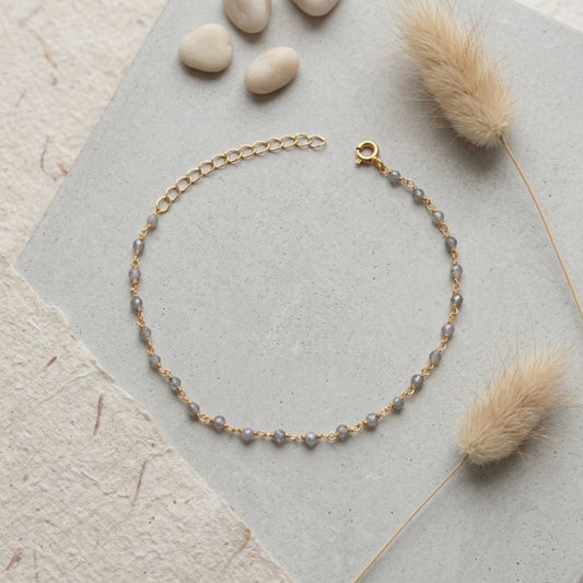 Pulsera Gaia de labradorita natural sobre plata de ley 925 dorada, en fondo gris