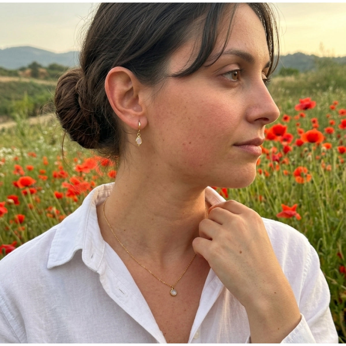 Mujer en un campo de amapolas con el Set Amor Propio de cuarzo rosa
